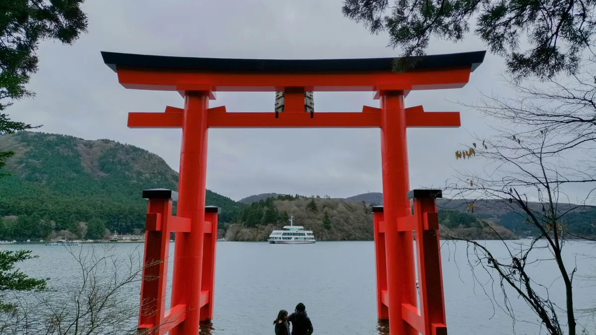 箱根・芦ノ湖の湖畔に立つ赤い鳥居と山並みが写っている(イメージ)